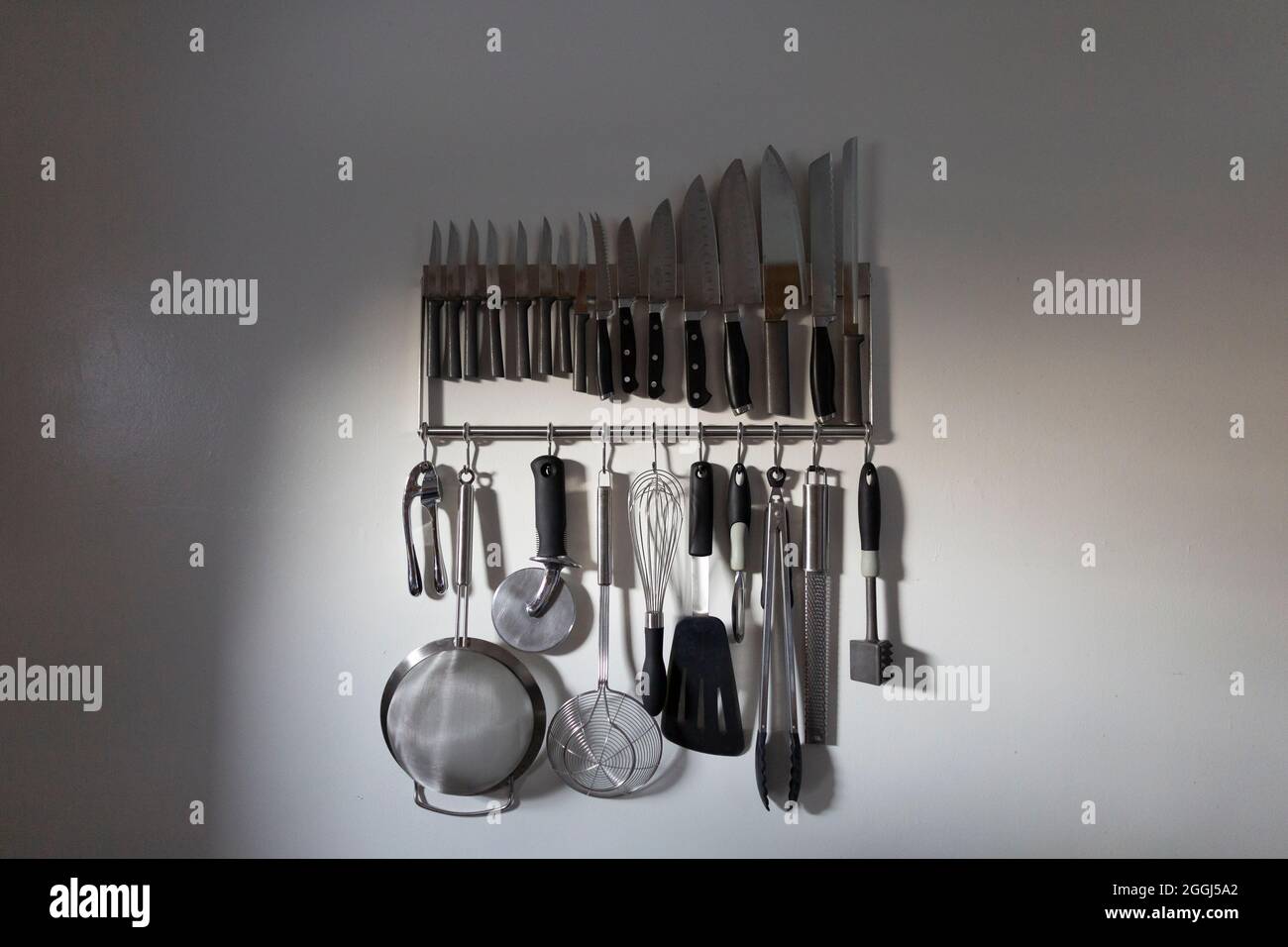 Gruppo di utensili da cucina Hanging interni in luce serale Foto Stock