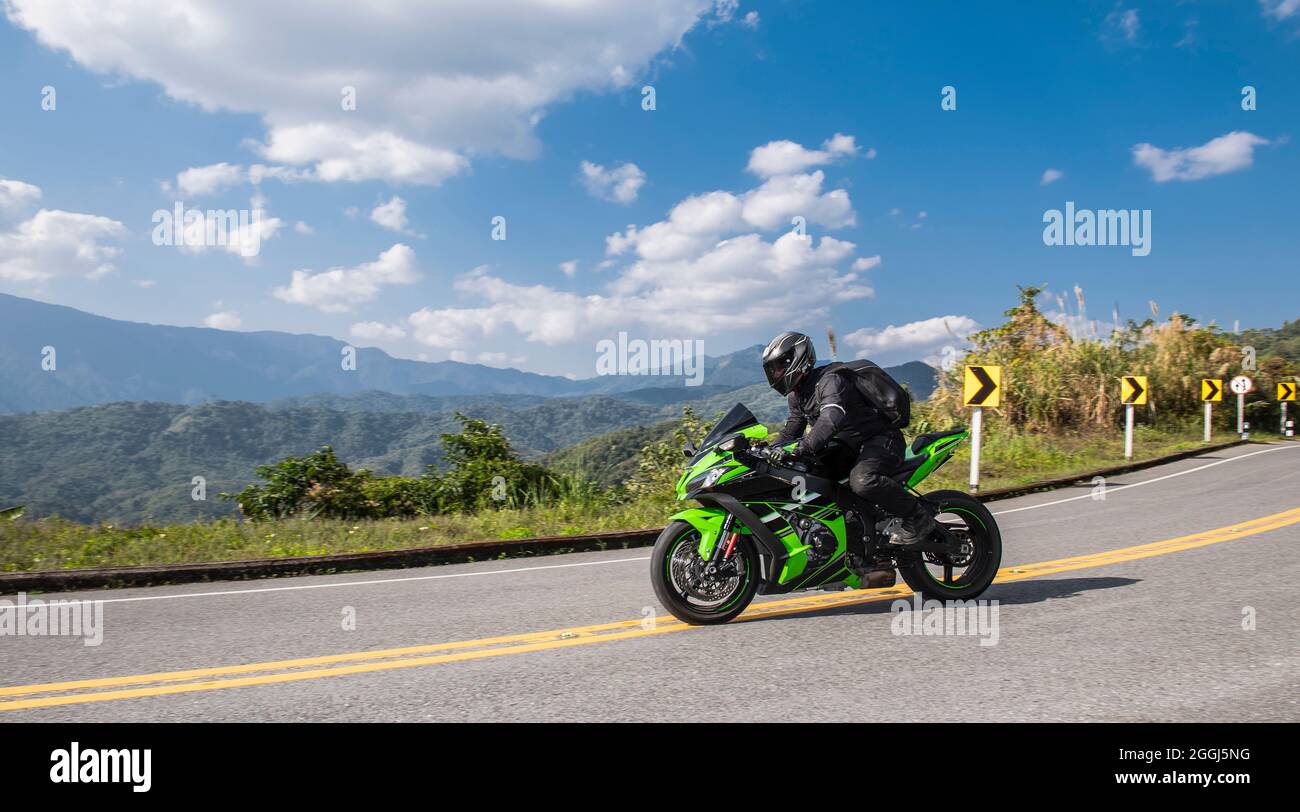 Uomo che guida la sua moto nelle colline del nord della Thailandia Foto Stock