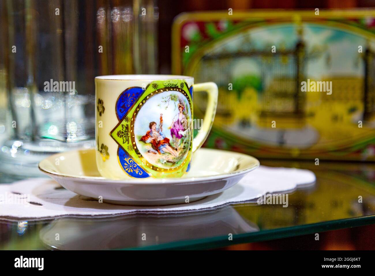 Vecchia tazza di cioccolato e piattino con scena dipinta al Museo del cioccolato Szamos a Budapest, Ungheria Foto Stock