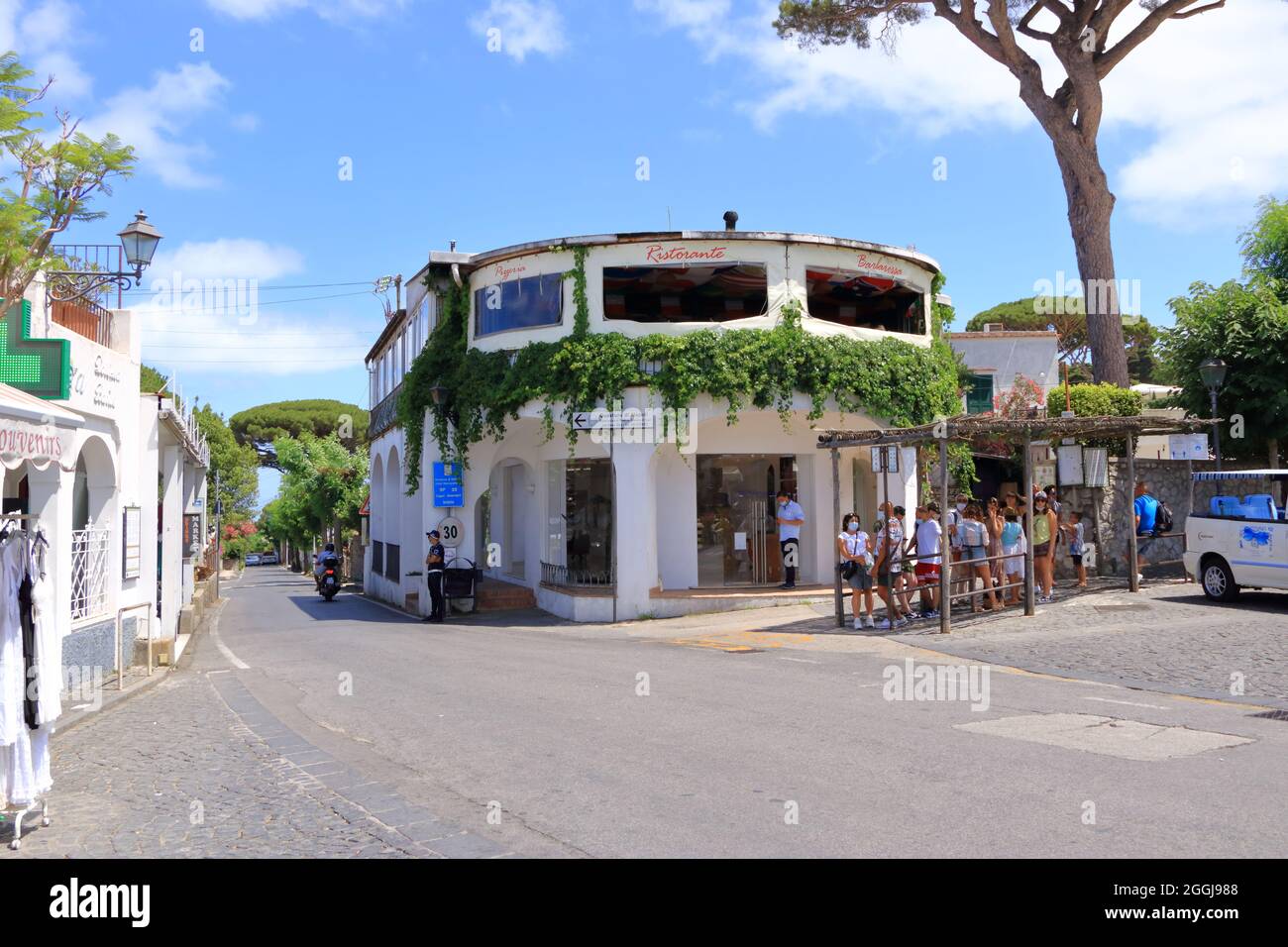 14 2021 luglio - Capri, Italia: Bella stradina della città di Anacapri, città mediterranea con alberi fioriti e case bianche Foto Stock