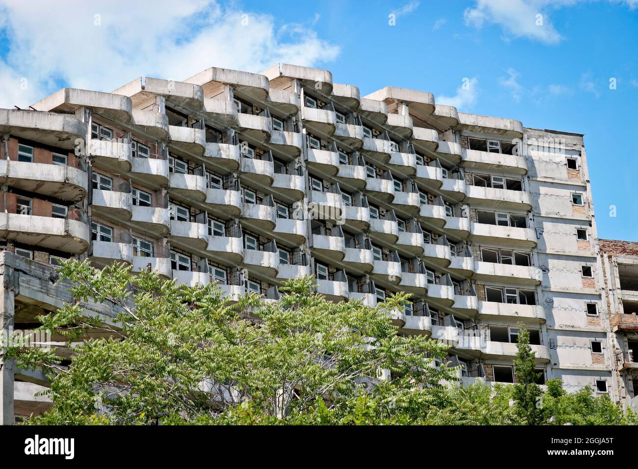 Abbandonato edificio sgretolante con balconi semicircolari - pericolo di collasso. Foto Stock