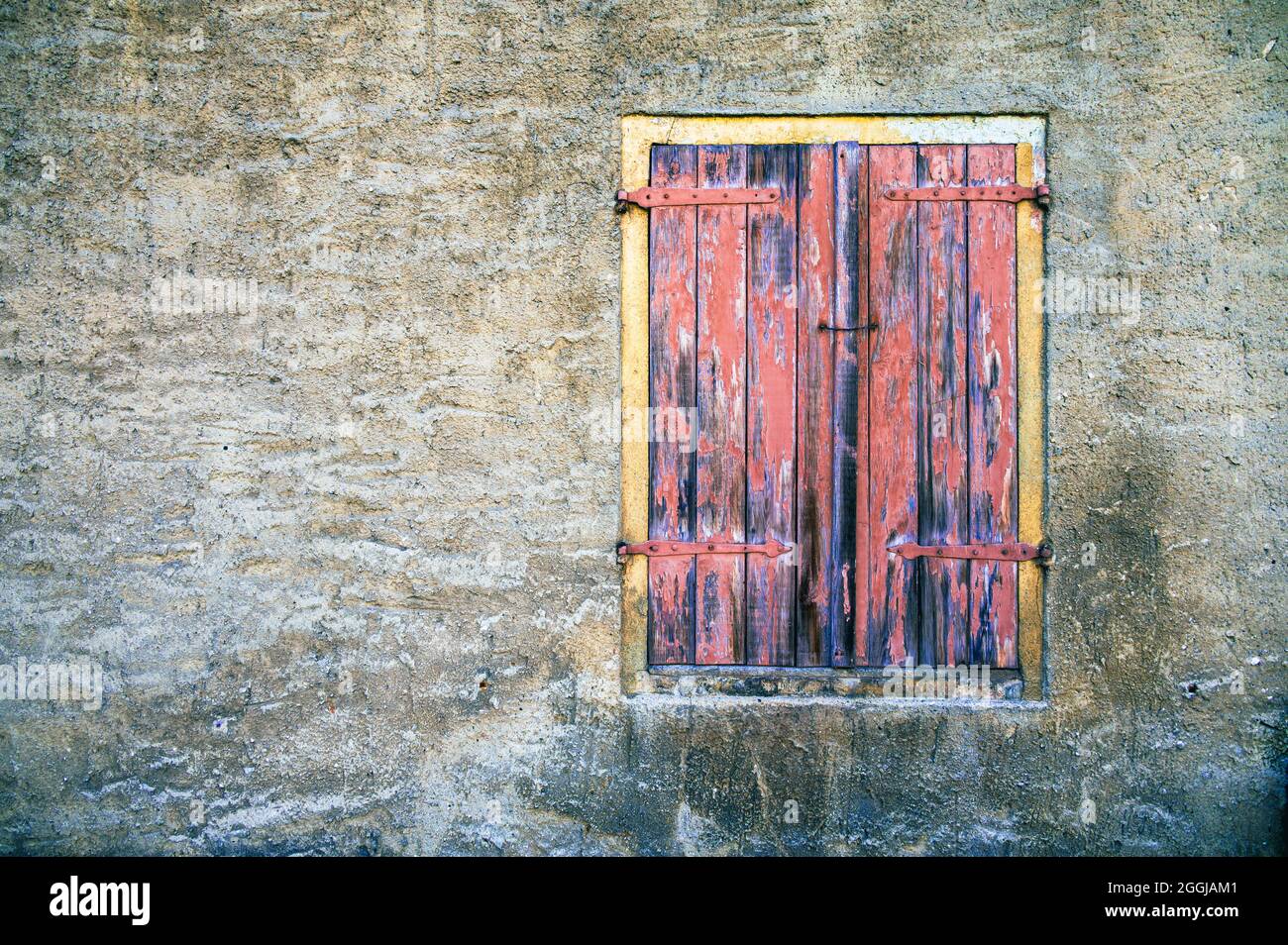 Facciata con intemperie di un edificio abbandonato con finestre e persiane chiuse Foto Stock
