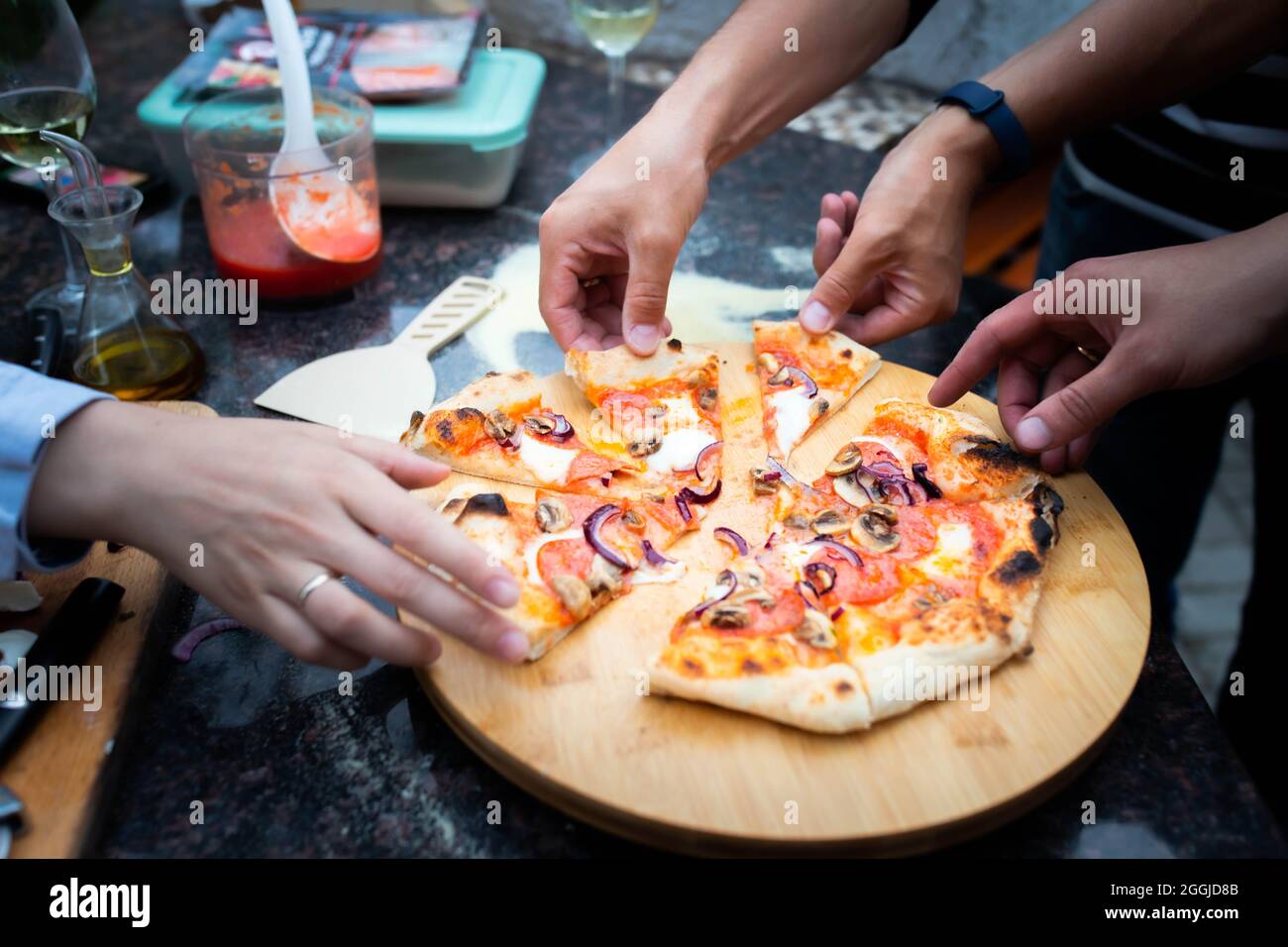 La famiglia mangia pizza fatta in casa dal forno Foto Stock