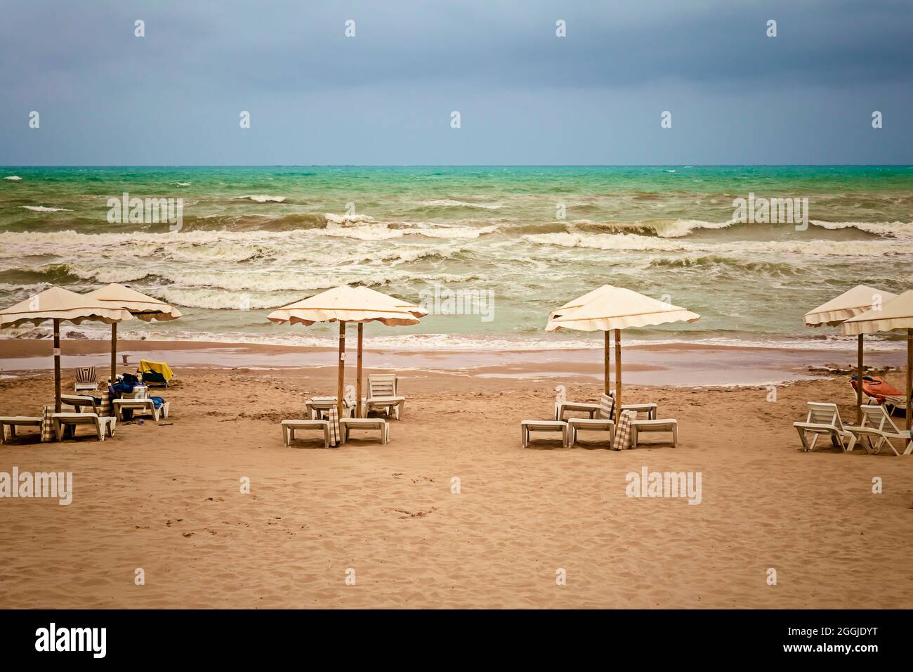 paesaggio con una spiaggia e cielo nuvoloso con il mare goffiato dalla tempesta Foto Stock