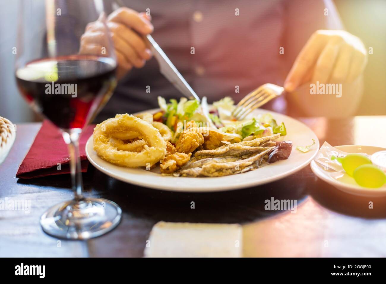 uomo con un piatto di pesce fritto ad un tavolo da ristorante Foto Stock