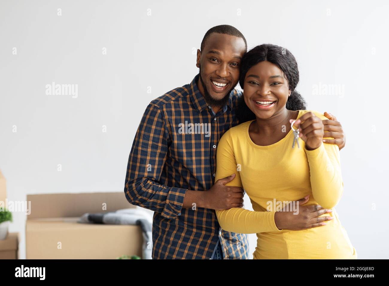 Proprietari felici. Allegri sposi neri che posano con le chiavi dalla loro nuova sede Foto Stock