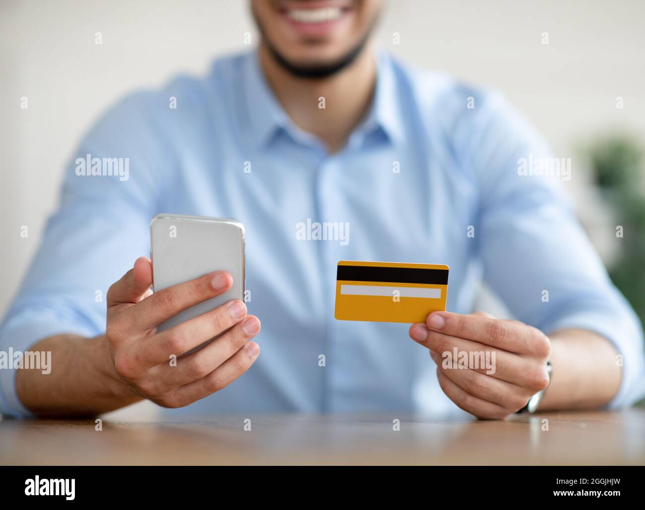 Shopping online. Primo piano del tipo arabo che detiene la carta di credito  e il cellulare, facendo e-pagamento, ordinando prodotti su internet Foto  stock - Alamy