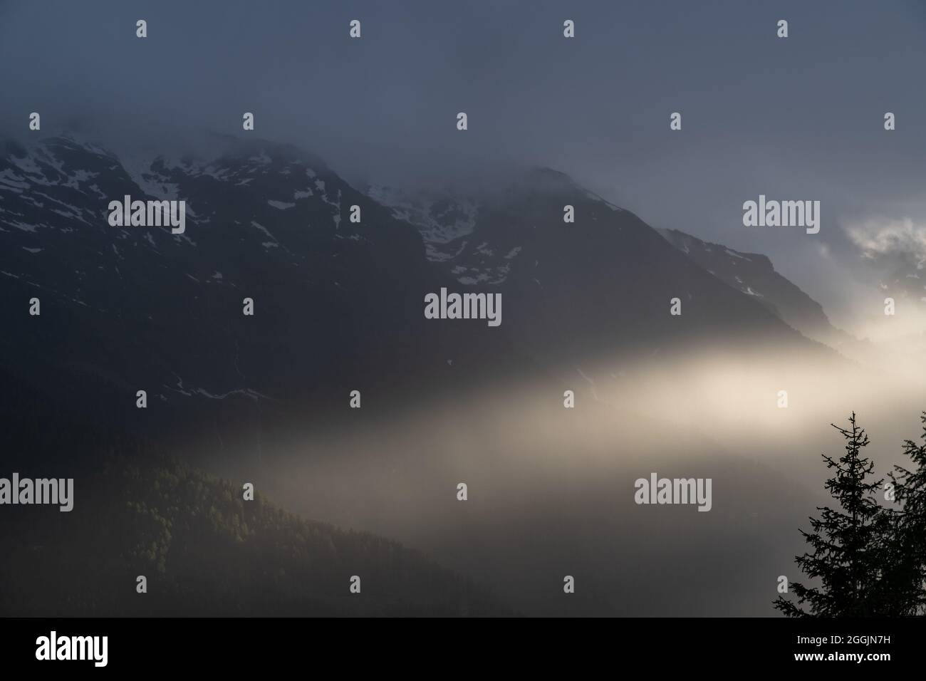 Europa, Austria, Tirolo, Alpi Ötztal, Pitztal, St. Leonhard im Pitztal, il raggio del sole si rompe attraverso la nuvola coperta Foto Stock