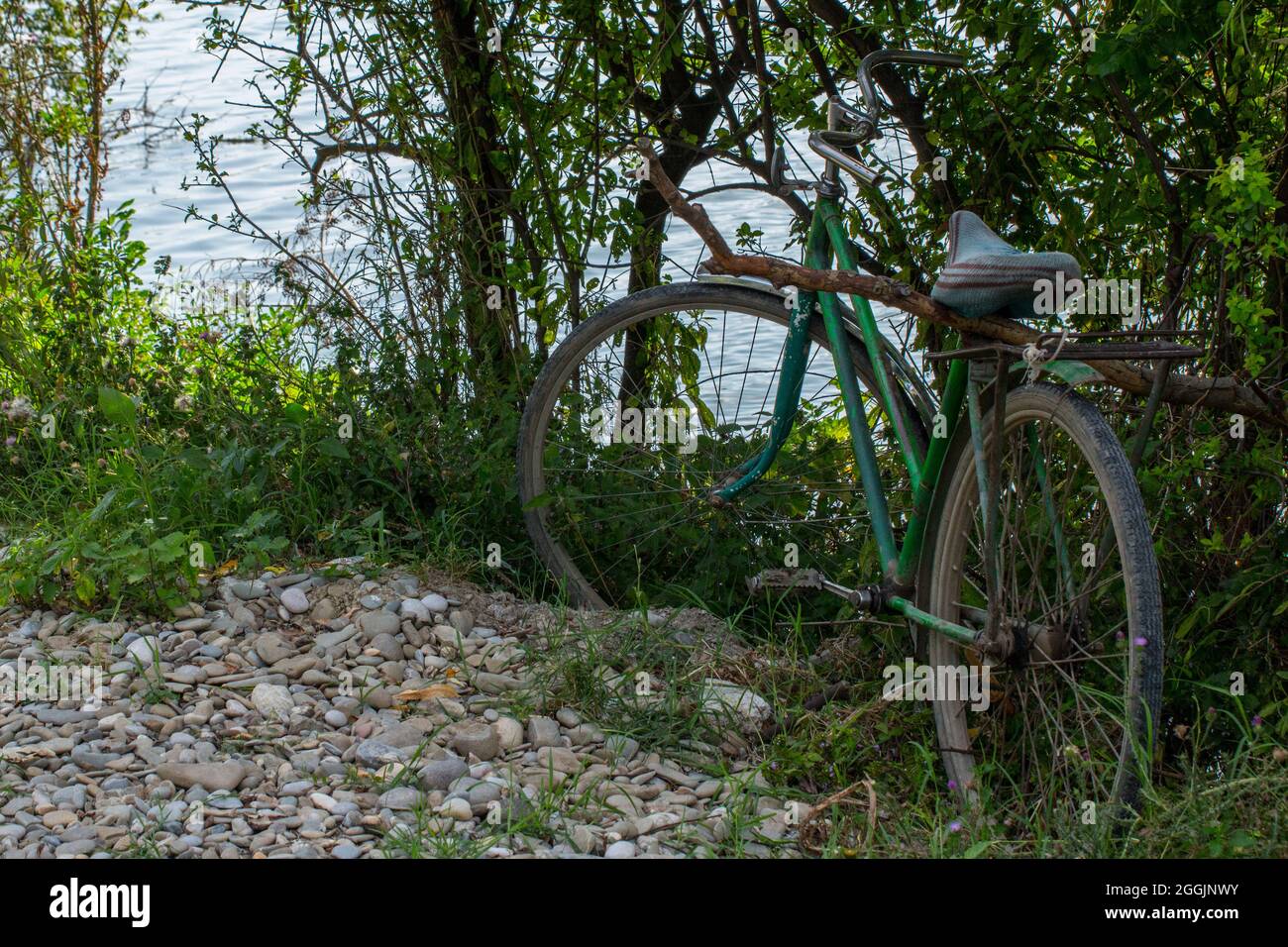 Bicicletta abbandonata vicino ad un lago. Foto Stock