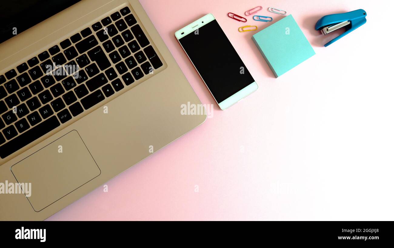 Elegante spazio di lavoro con computer portatile, smartphone e moderni accessori per l'ufficio Foto Stock