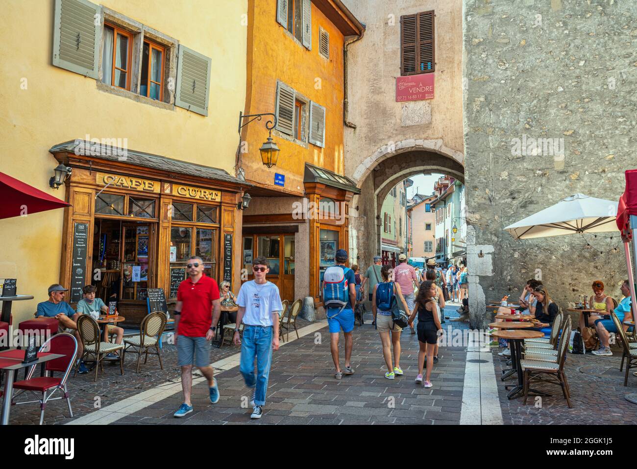 I turisti passeggiano per le antiche strade del centro storico di Annecy. Souvenir, bar e caffetterie all'aperto attirano i turisti. Annecy, Francia Foto Stock