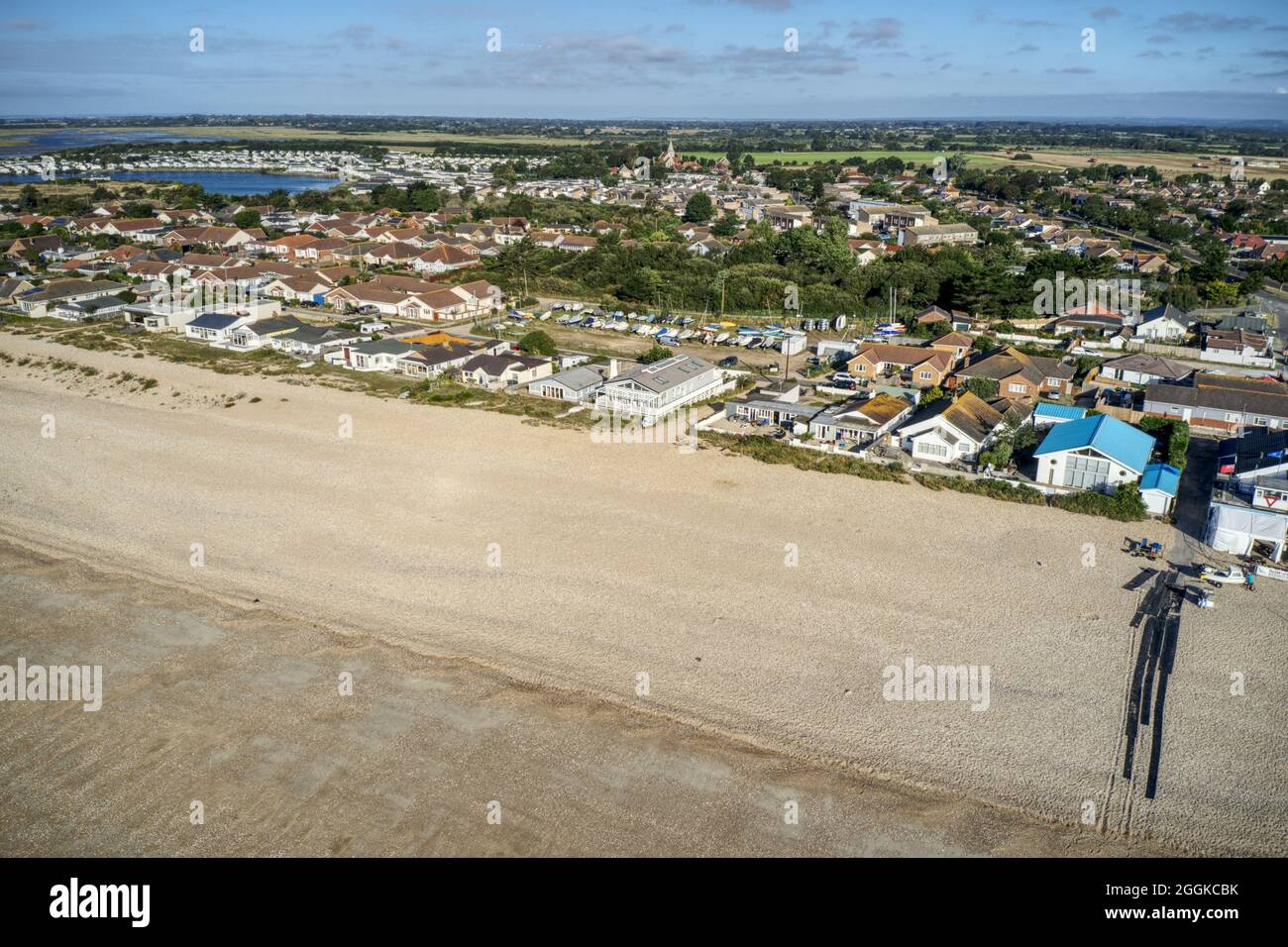Vista aerea del lungomare di Pagham e della spiaggia con lo Yacht Club e rampa di lancio barca fino al mare in vista. Foto Stock Vista aerea del lungomare di Pagham e della spiaggia con lo Yacht Club e rampa di lancio barca fino al mare in vista. Foto Stock