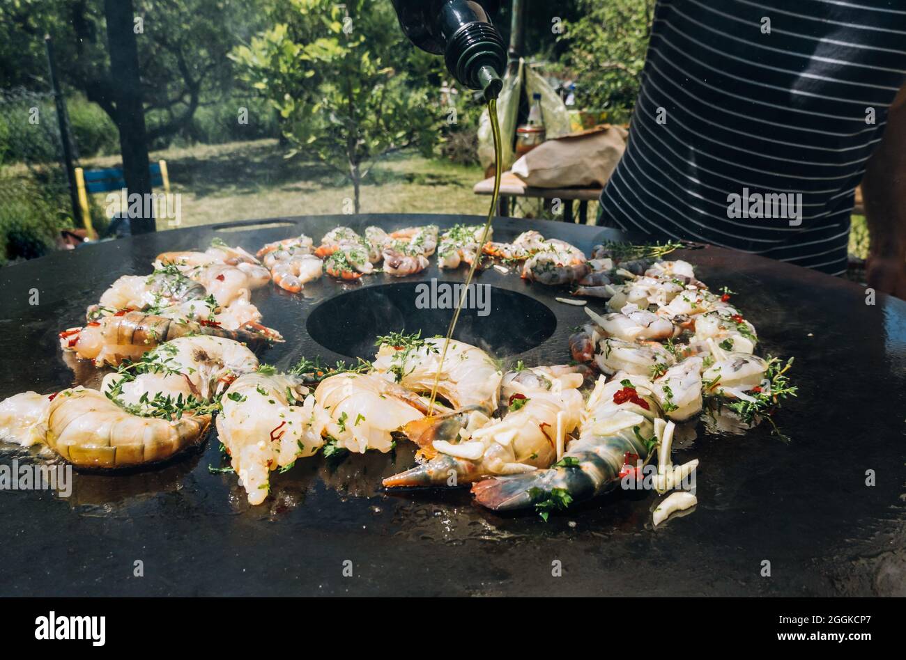 Frittura di gamberetti con erbe su una griglia di barbecue plancha con timo Foto Stock