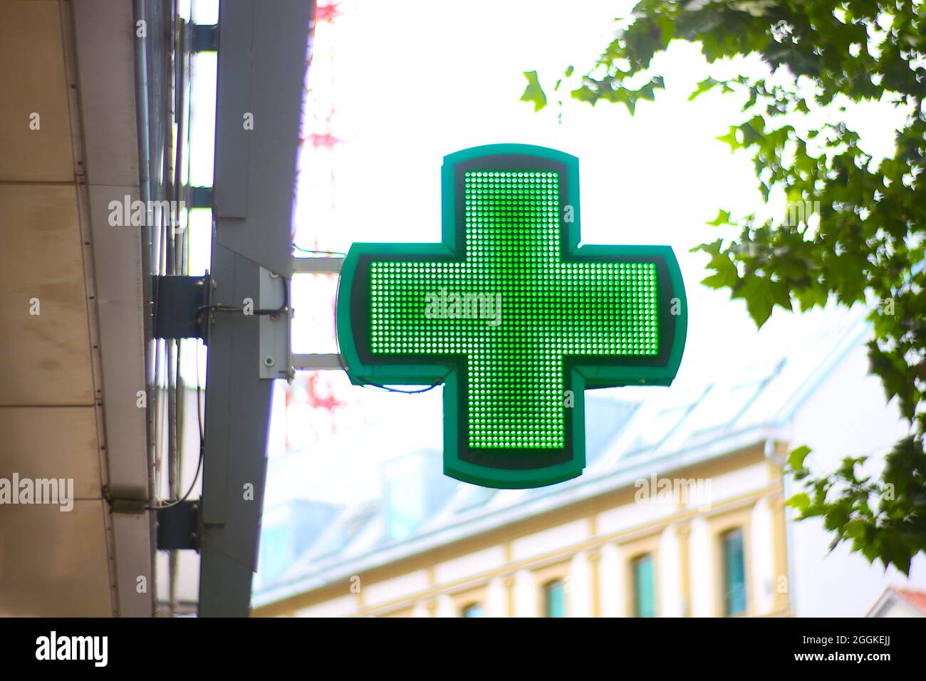 Croce verde come segno pubblicitario a LED. Foto Stock