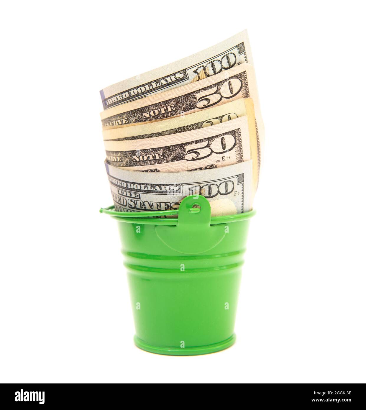 Bollette del dollaro americano in un secchio verde giocattolo isolato su bianco Foto Stock