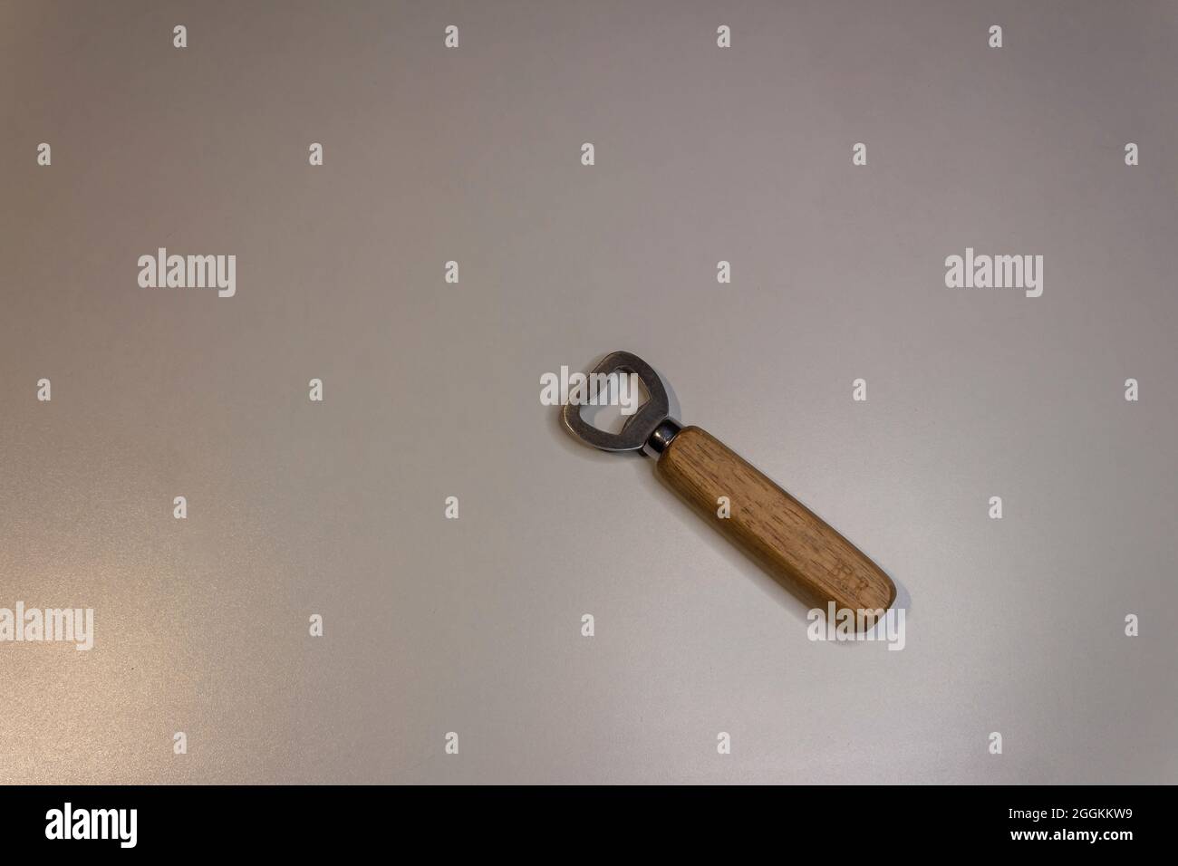 Apribottiglie. Apribottiglie su sfondo bianco. Apribottiglie in legno e acciaio su un tavolo bianco Foto Stock