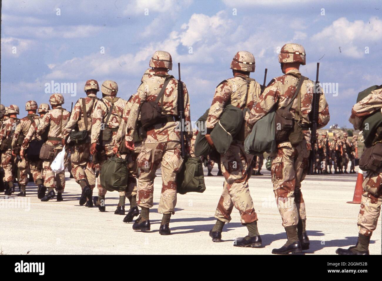 Fort Hood Texas USA, 1990: I soldati dell'esercito degli Stati Uniti che indossano uniformi di camouflage color deserto e trasportano armi e attrezzature si preparano a salire a bordo degli aerei sulla strada per servire nel conflitto in Medio Oriente. ©Bob Daemmrich Foto Stock