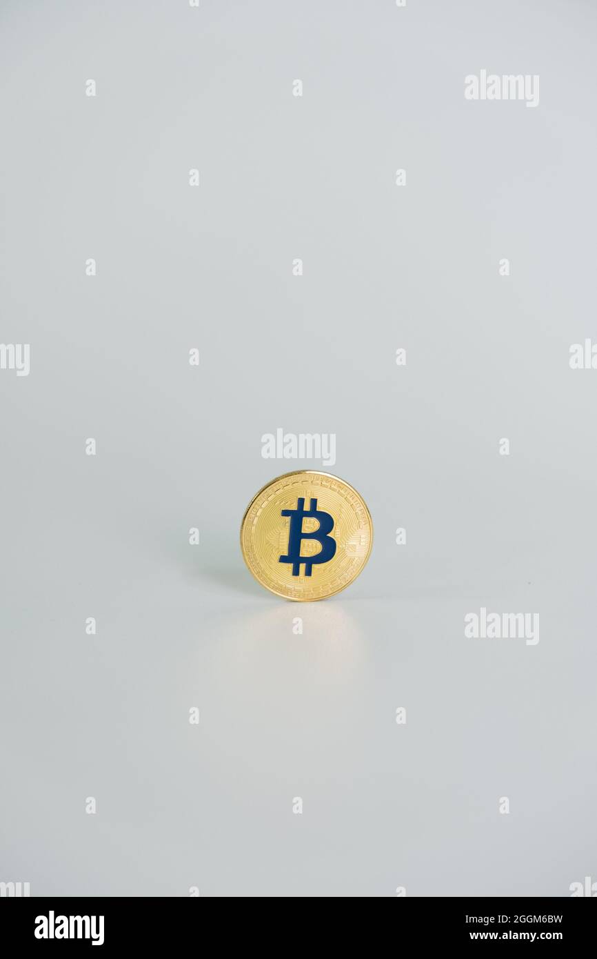 Una moneta di colore oro Bitcoin con la lettera 'B' di colore blu, centrata su sfondo grigio chiaro. Bitcoin - BTC bit Coin - Crypto valuta. Foto Stock