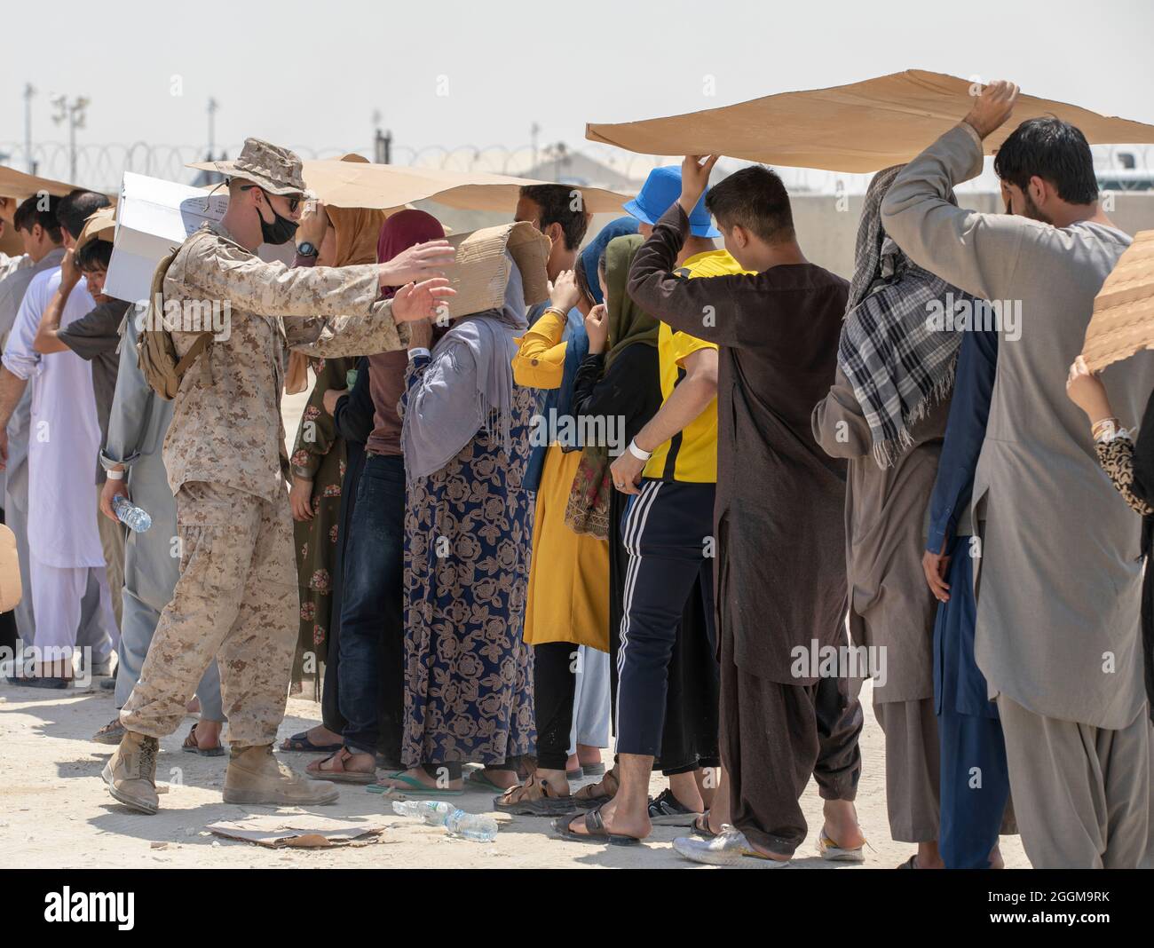 Una Marina degli Stati Uniti dirige evacuati qualificati in linea in attesa di fornitura alla base aerea di al Udeid, Qatar, 28 agosto 2021. Il Dipartimento della Difesa sta sostenendo altre agenzie per il trasferimento, l'elaborazione dei visti e il reinsediamento del personale civile statunitense, dei richiedenti di visti per immigrati speciali e di altri individui a rischio (Stati Uniti Foto dell'esercito dello staff Sgt. Thao vero) Foto Stock