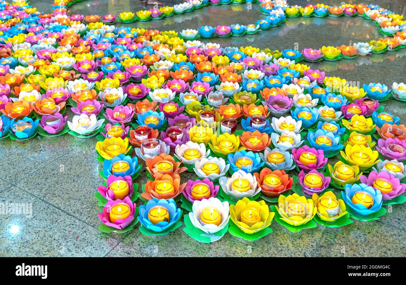 Candele colorate ornate sono illuminate nel cortile del tempio per celebrare il compleanno di Buddha, pregando per la pace di tutti. Foto Stock