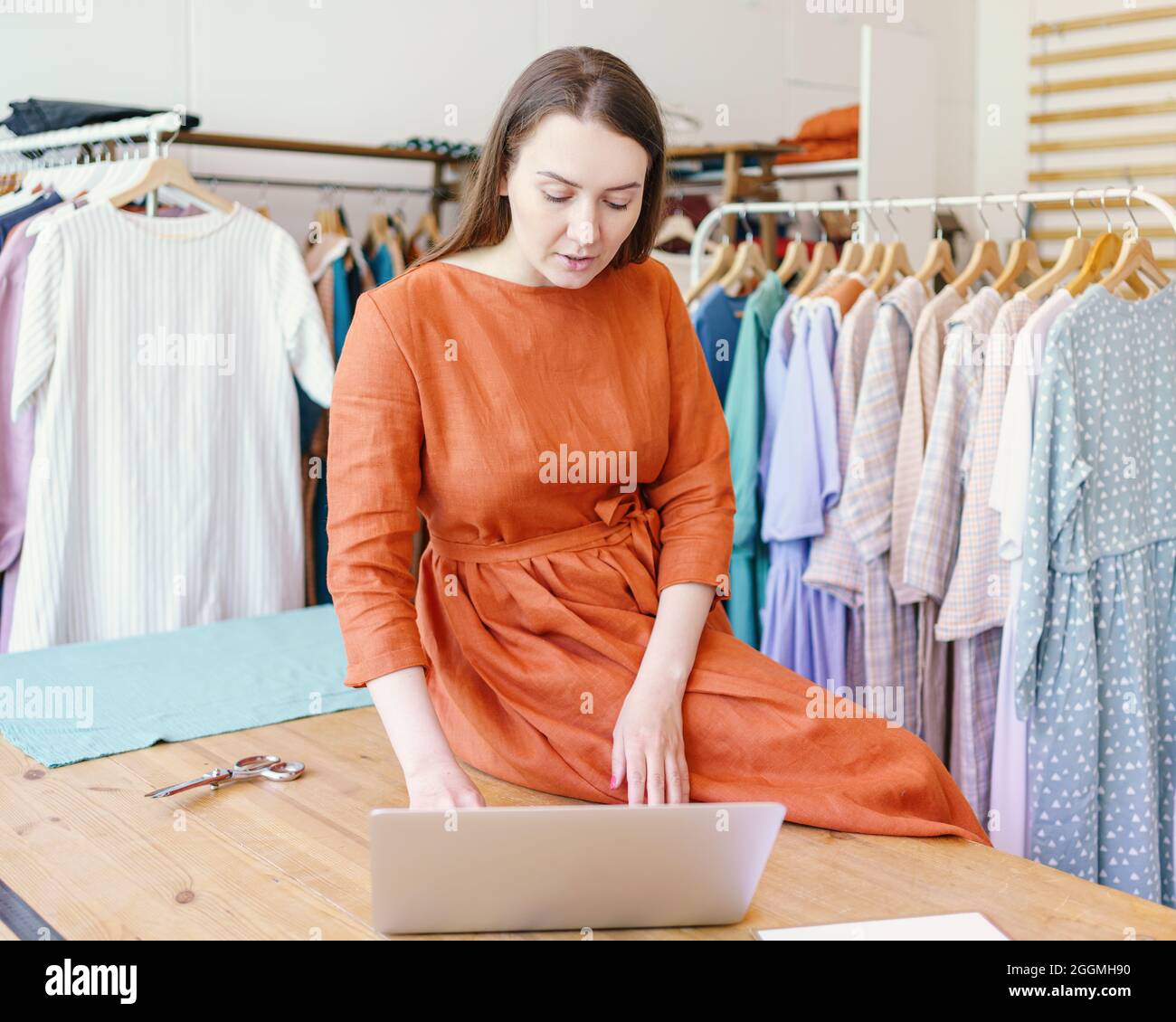 Stilista di moda femminile che crea online design di abbigliamento su laptop Foto Stock