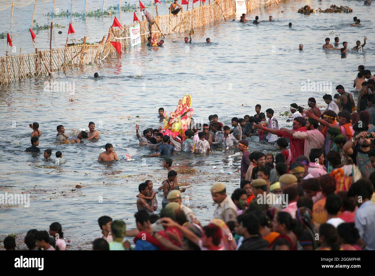 Gli indù prendono parte ad una processione religiosa per immergere l'idolo di Lord Ganesha nel fiume Yamuna in occasione di Ganesh Visarjan a Nuova Delhi. Foto Stock