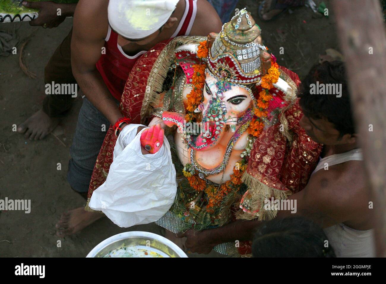 Gli indù prendono parte ad una processione religiosa per immergere l'idolo di Lord Ganesha nel fiume Yamuna in occasione di Ganesh Visarjan a Nuova Delhi. Foto Stock