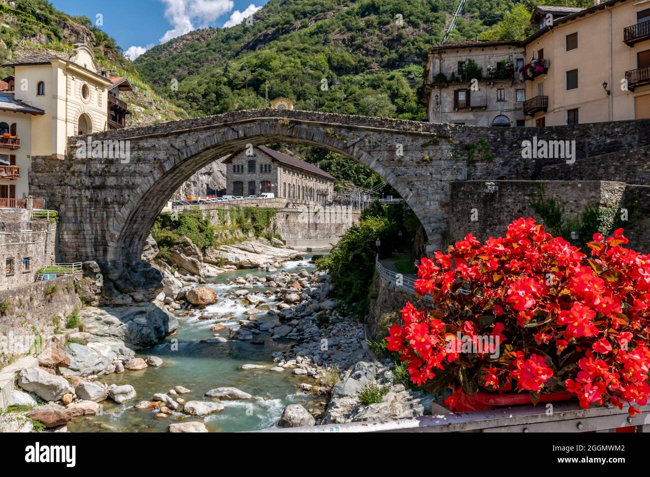 Bellissimi fiori rossi decorano il centro storico di Pont Saint Martin, Valle d'Aosta, Italia, vicino all'antico ponte romano Foto Stock