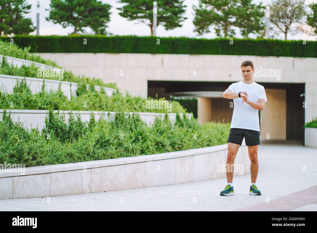Atleta runner che guarda l'orologio con fascia cardio. Uomo che controlla  il suo gadget prima di correre Foto stock - Alamy