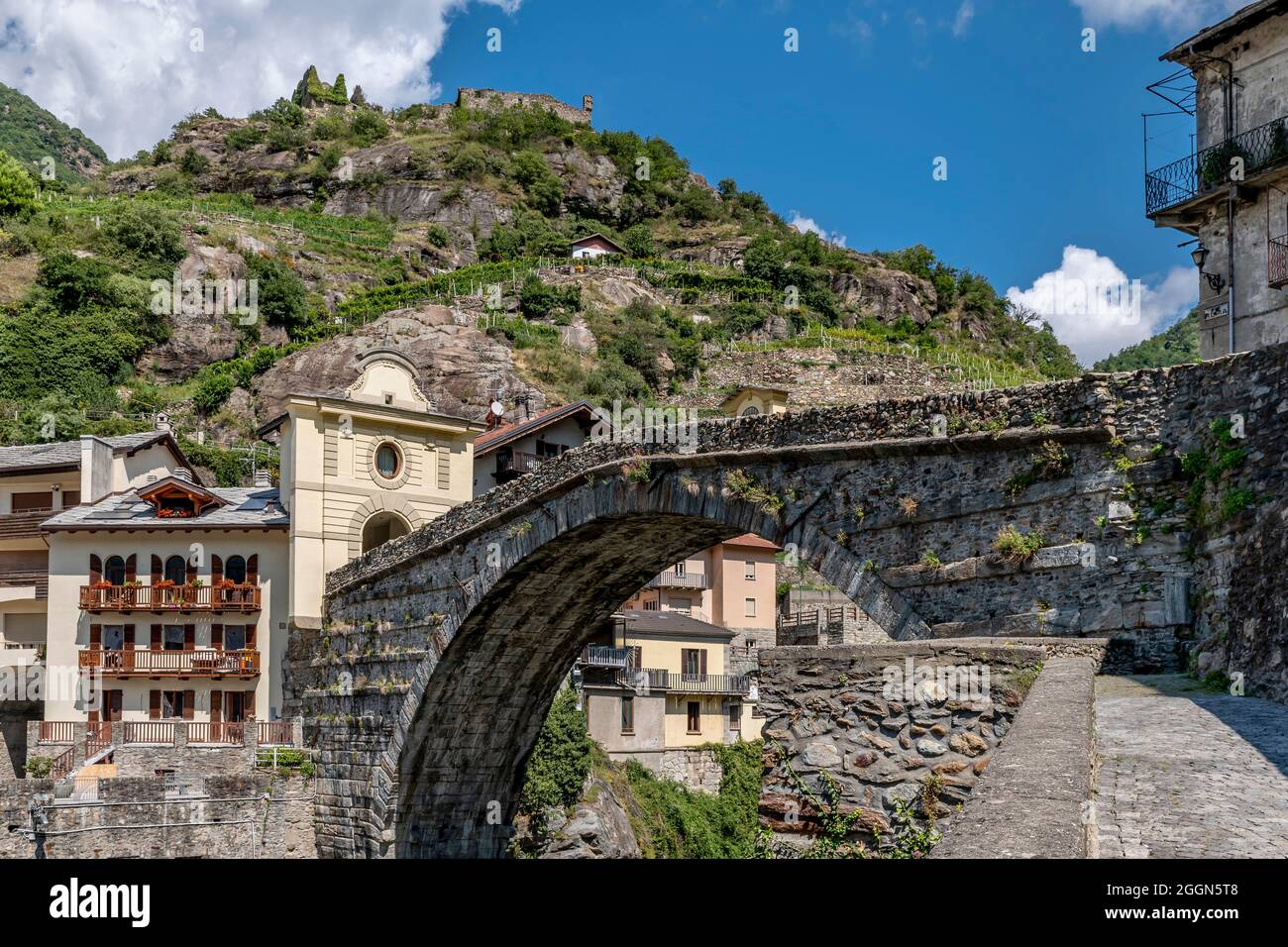 L'antico ponte di Pont Saint Martin, nel centro storico dell'omonimo borgo, in una giornata di sole, Valle d'Aosta, Italia Foto Stock