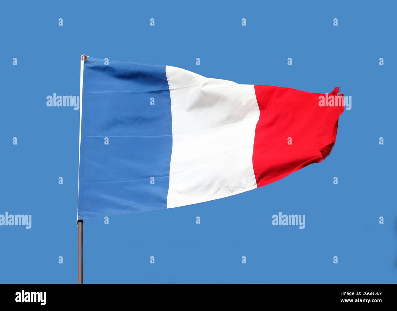 Bandiera francese che vola sul flagpole su sfondo blu cielo Foto Stock