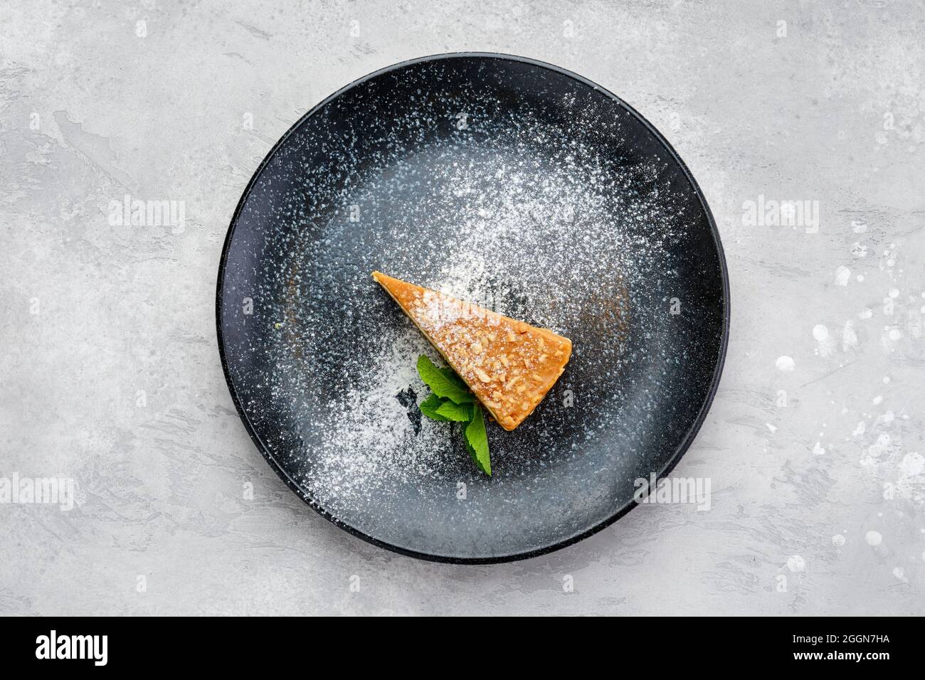 Vista dall'alto di un pezzo triangolare di torta al formaggio al caramello su un piatto Foto Stock