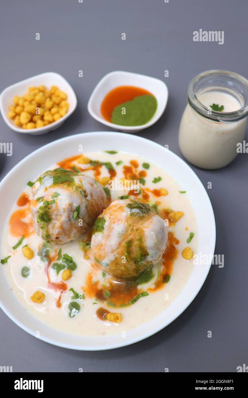 Dahi Bhalla o Dahi vada è un tipo di piatto di cappellano indiano. Si prepara immergendo urad dal vadas in yogurt cremoso con chutney verde e rosso. Foto Stock