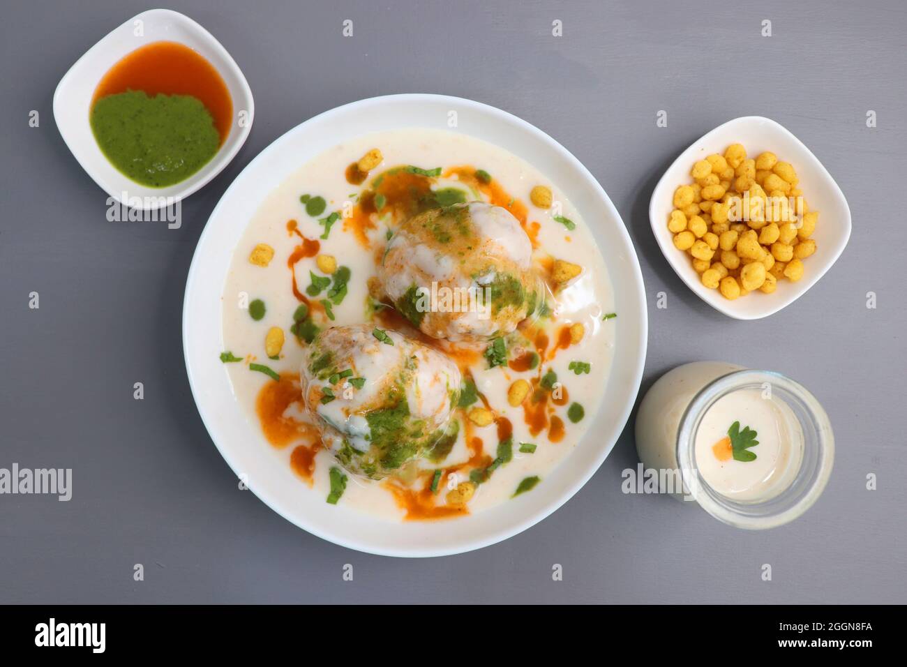 Dahi Bhalla o Dahi vada è un tipo di piatto di cappellano indiano. Si prepara immergendo urad dal vadas in yogurt cremoso con chutney verde e rosso. Foto Stock