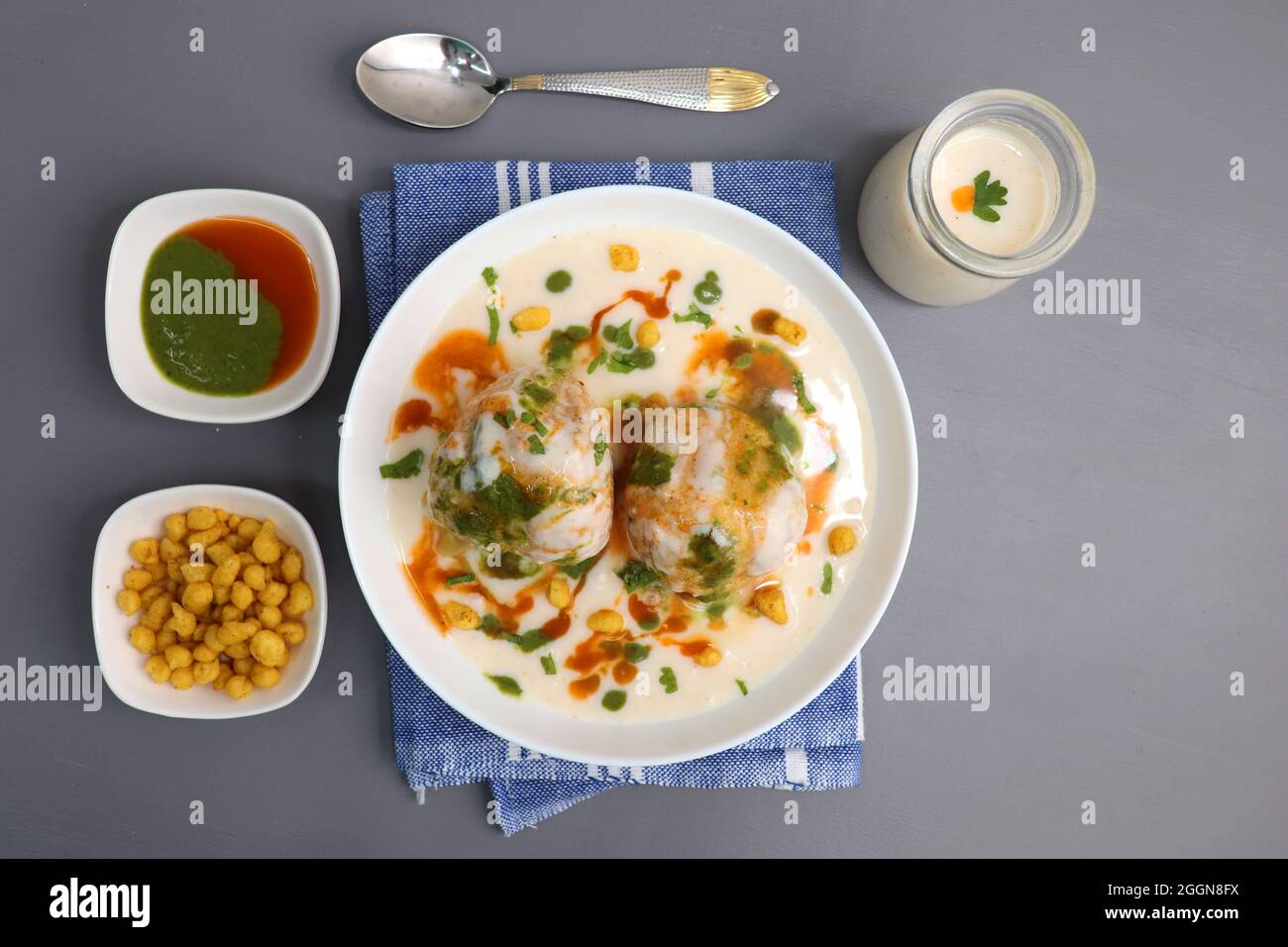 Dahi Bhalla o Dahi vada è un tipo di piatto di cappellano indiano. Si prepara immergendo urad dal vadas in yogurt cremoso con chutney verde e rosso. Foto Stock