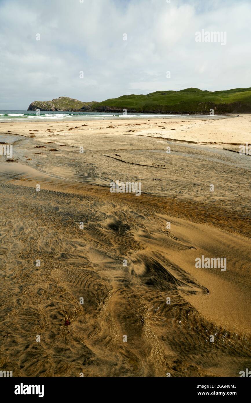 Dettagli fluviali su una spiaggia dove la torba è lavata fuori nella sabbia e la marea crea motivi belli. Spiaggia di Reef nell'Isola di Lewis. Foto Stock