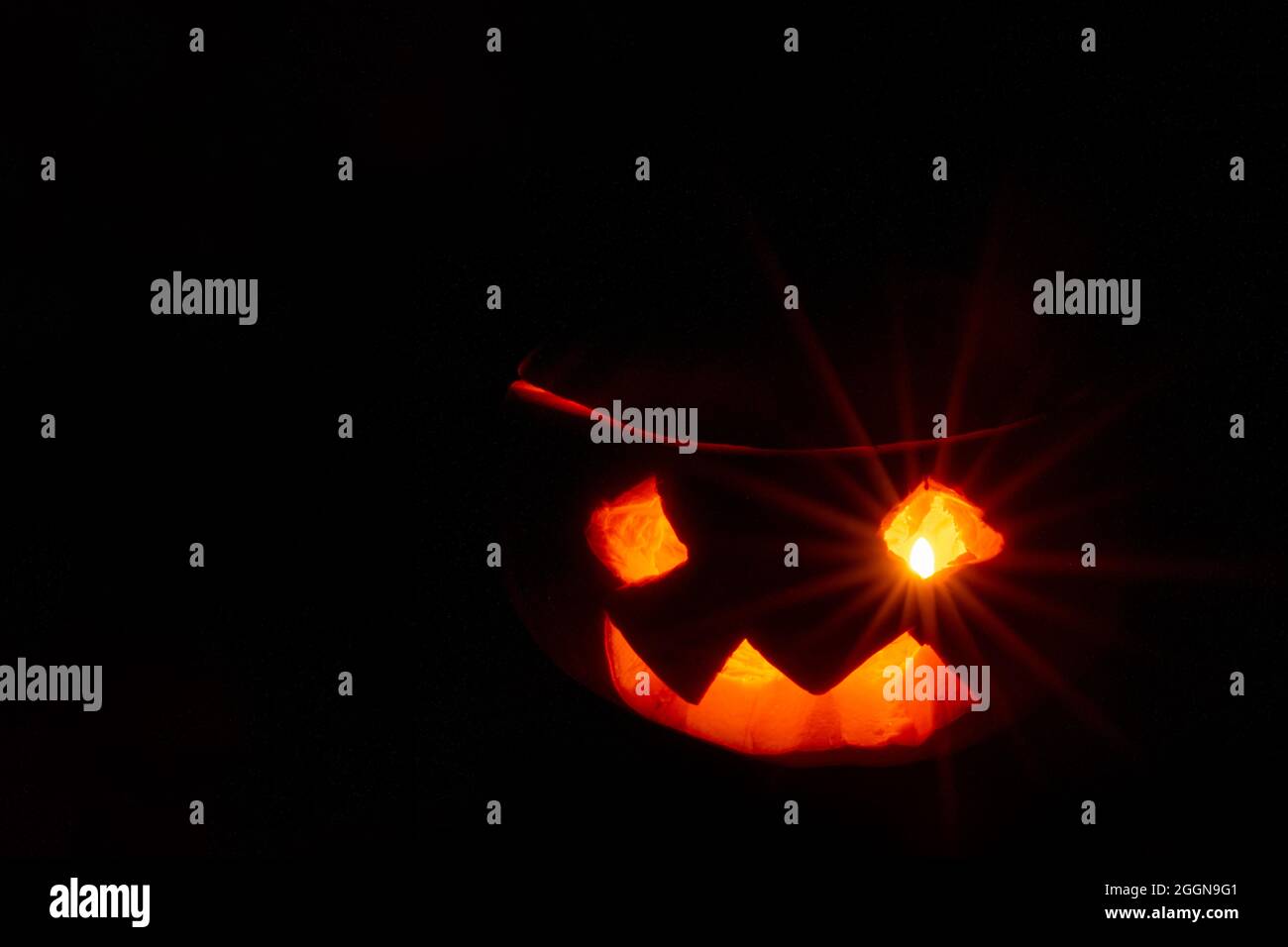 Halloween sorridi zucca e occhi spaventosi per una festa, Jack Lantern isolato su sfondo nero. Lanterna di zucca incandescente occhio. Può essere utilizzato come cartolina Foto Stock