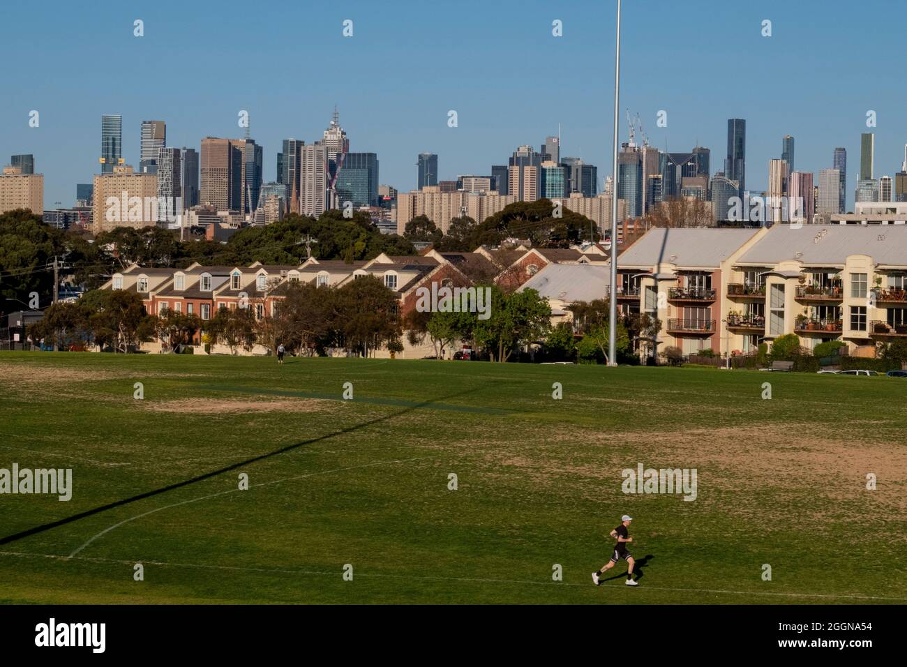 Un uomo si esercita di fronte allo skyline di Melbourne. Victoria, Australia Foto Stock