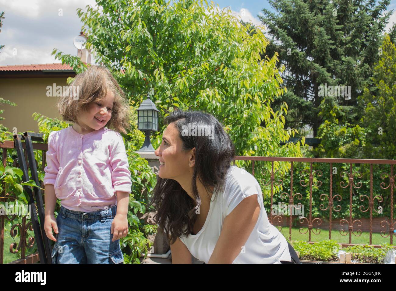 bambina e giovane donna che raccolgono menta fresca insieme. Famiglia. Foto Stock