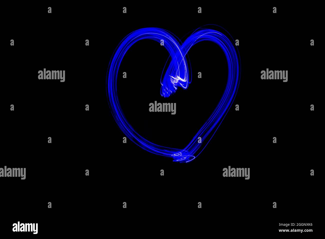 Pittura leggera della forma del cuore. Cuore disegnato con luci al neon blu. Fotografia a lunga esposizione. Isolato su nero. Febbraio 14 San Valentino sfondo. Foto Stock