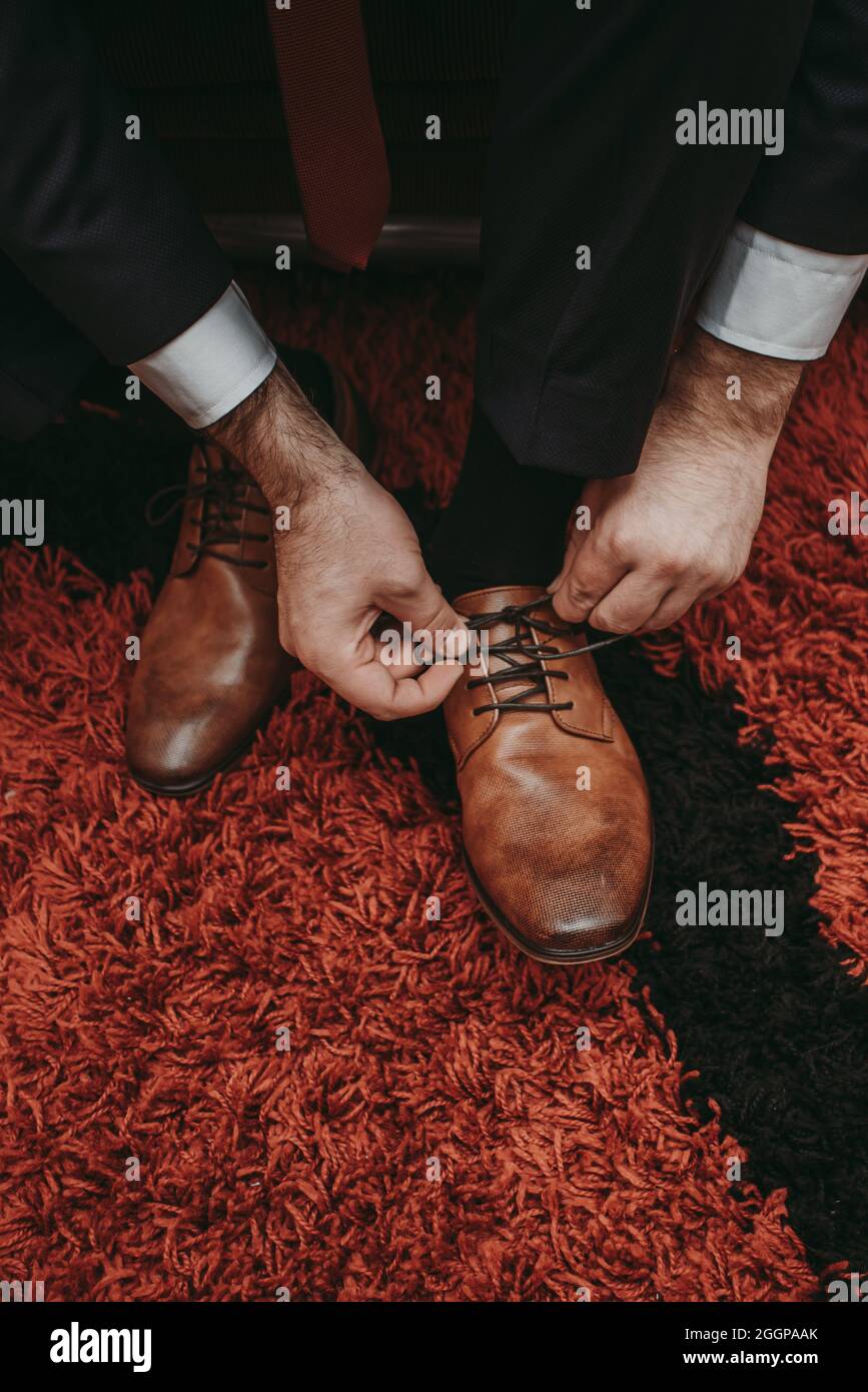 sposo che lega le scarpe marroni di cerimonia nuziale Foto Stock