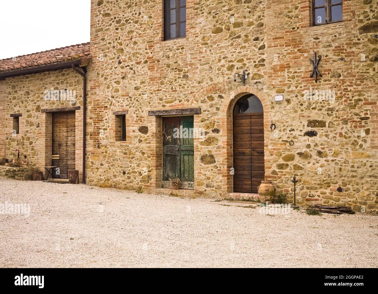 La facciata di un casale rurale in pietra con porte e finestre in legno  nella campagna italiana (Toscana, Italia, Europa Foto stock - Alamy