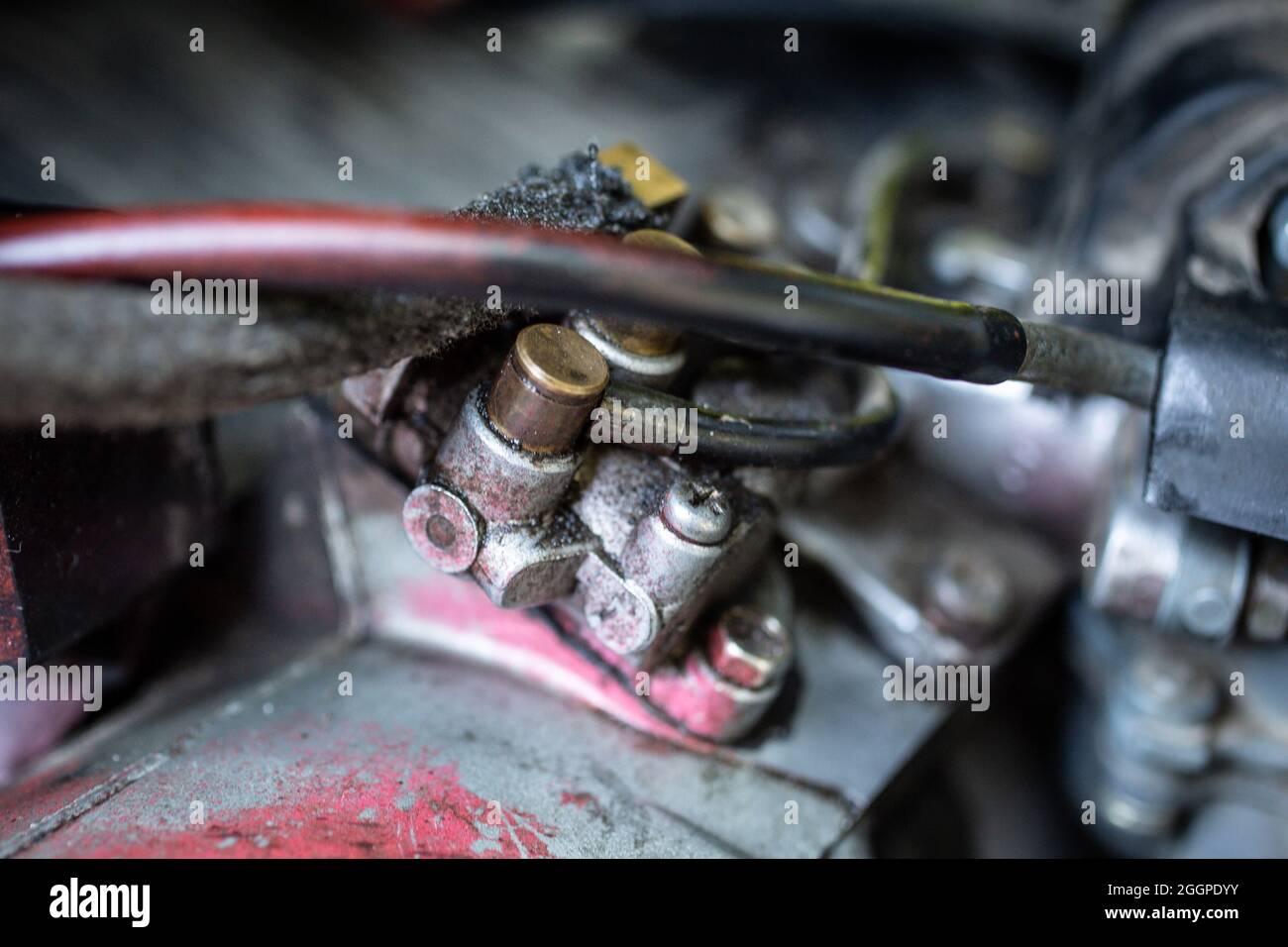 Primo piano di un carburatore a benzina e di un cavo Foto Stock