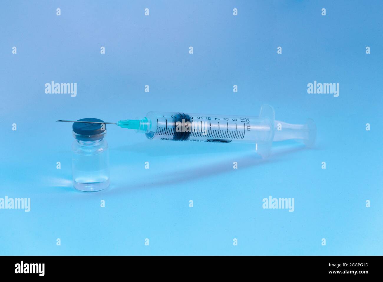 siringa di vaccino bianca su sfondo blu Foto Stock