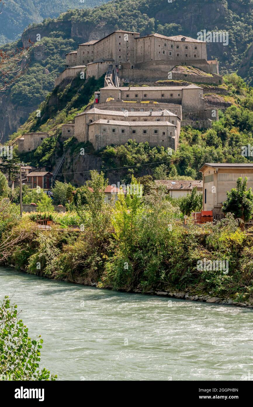 Il fiume Dora Baltea scorre sotto la collina del Forte di Bard, Valle d'Aosta, Italia Foto Stock