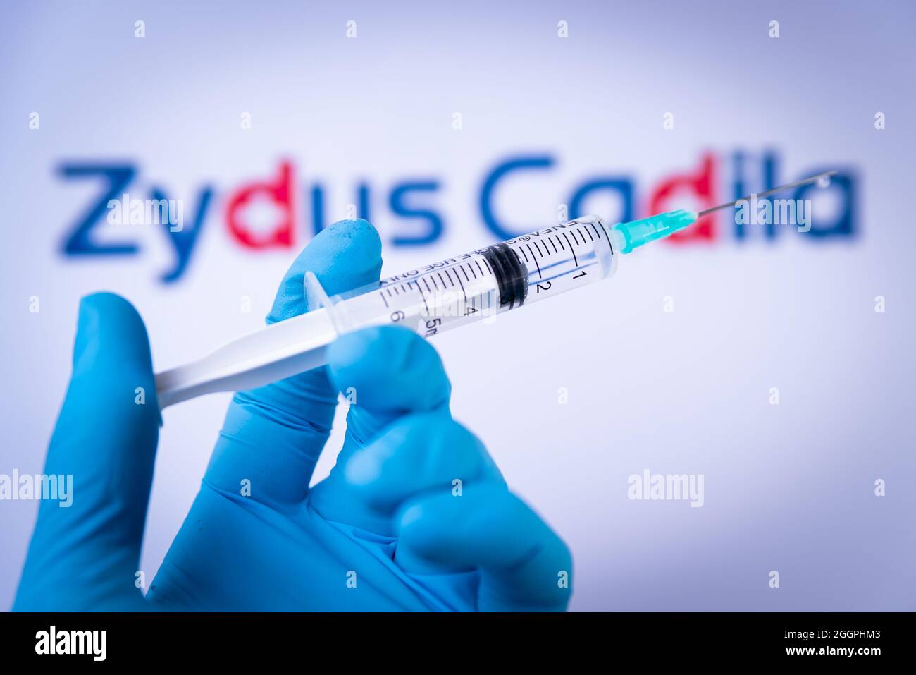 In questa foto illustrazione una mano in guanti medici tenere una siringa di fronte al logo Zydus Cadila a Barcellona, Spagna il 2 settembre 2021. Zydus Cadel Foto Stock