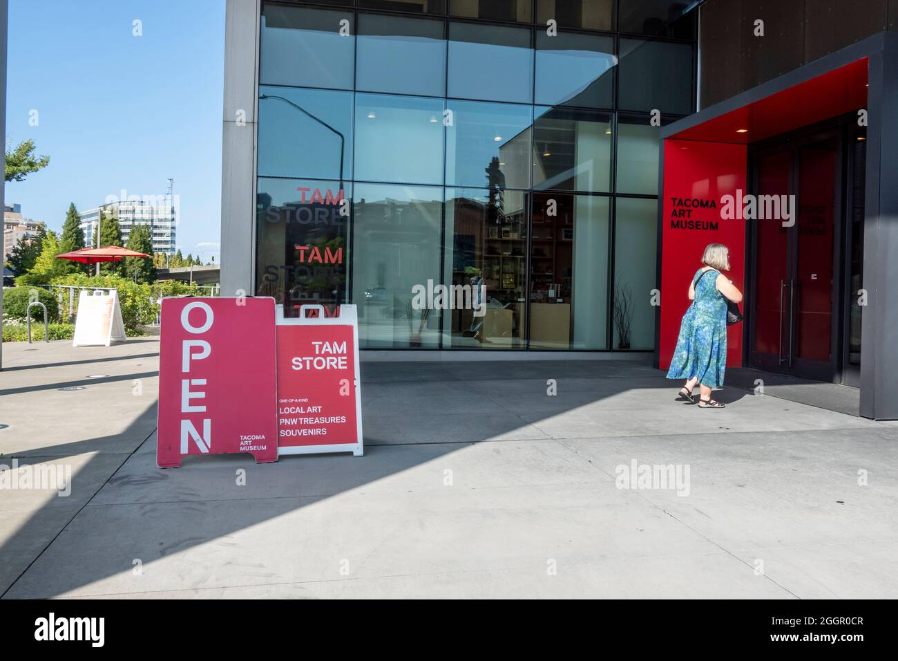 Tacoma, WA USA - circa Agosto 2021: Vista stradale di una donna che entra nel museo d'arte di Tacoma in una giornata soleggiata e senza nuvole. Foto Stock