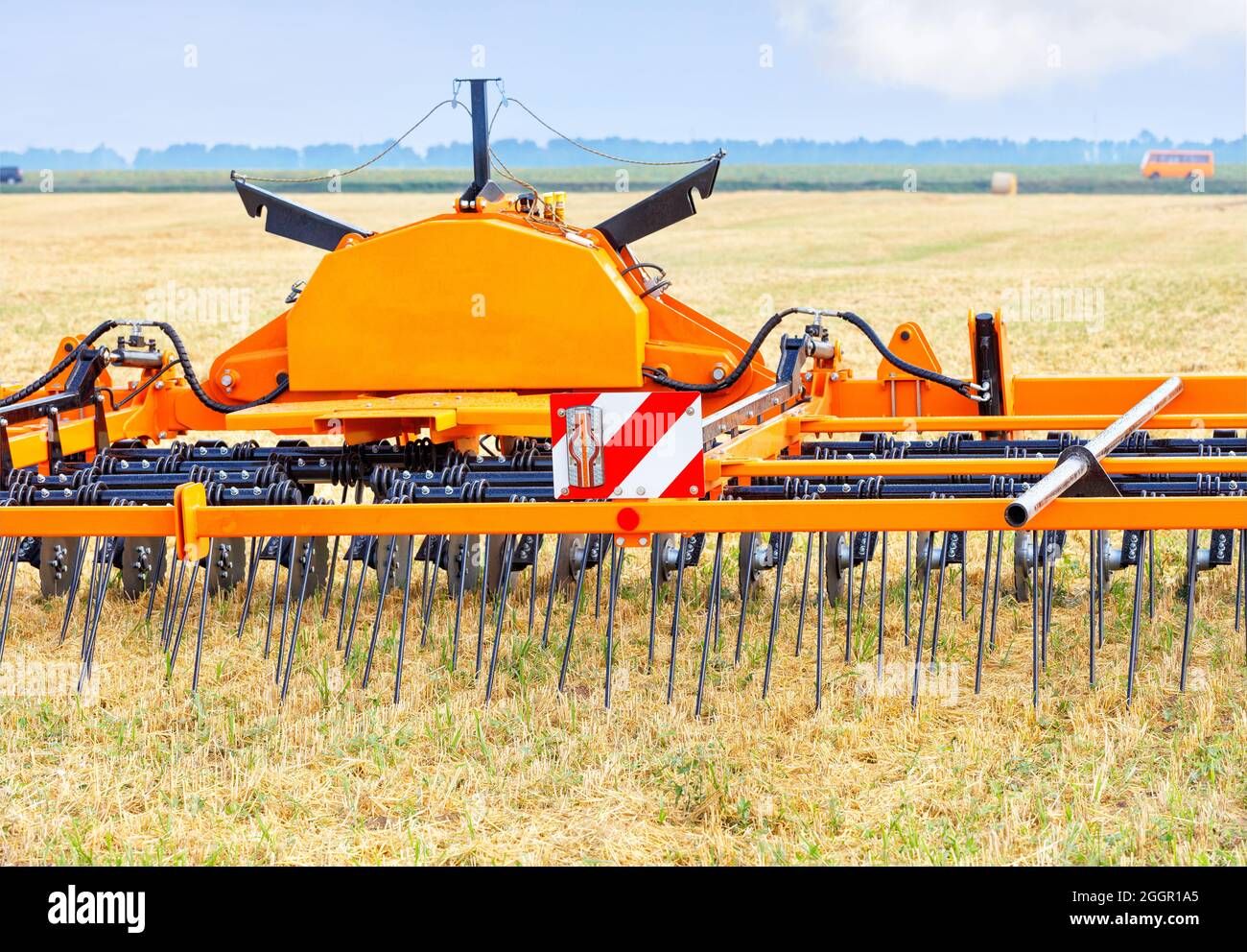 Attrezzo agricolo trainato per una distribuzione uniforme del terreno, tagliando la paglia dopo il raccolto e migliorando significativamente il pretrattamento del terreno prima della semina. Foto Stock