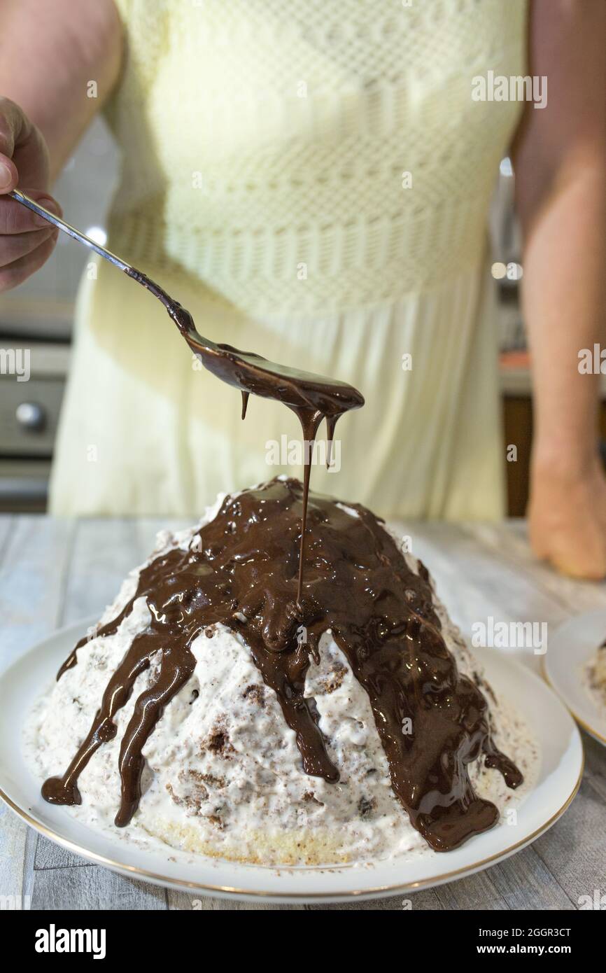 Il processo di preparazione dello smalto al cioccolato. Passo dopo passo. Una donna versa lo smalto su torte fatte in casa. Foto Stock