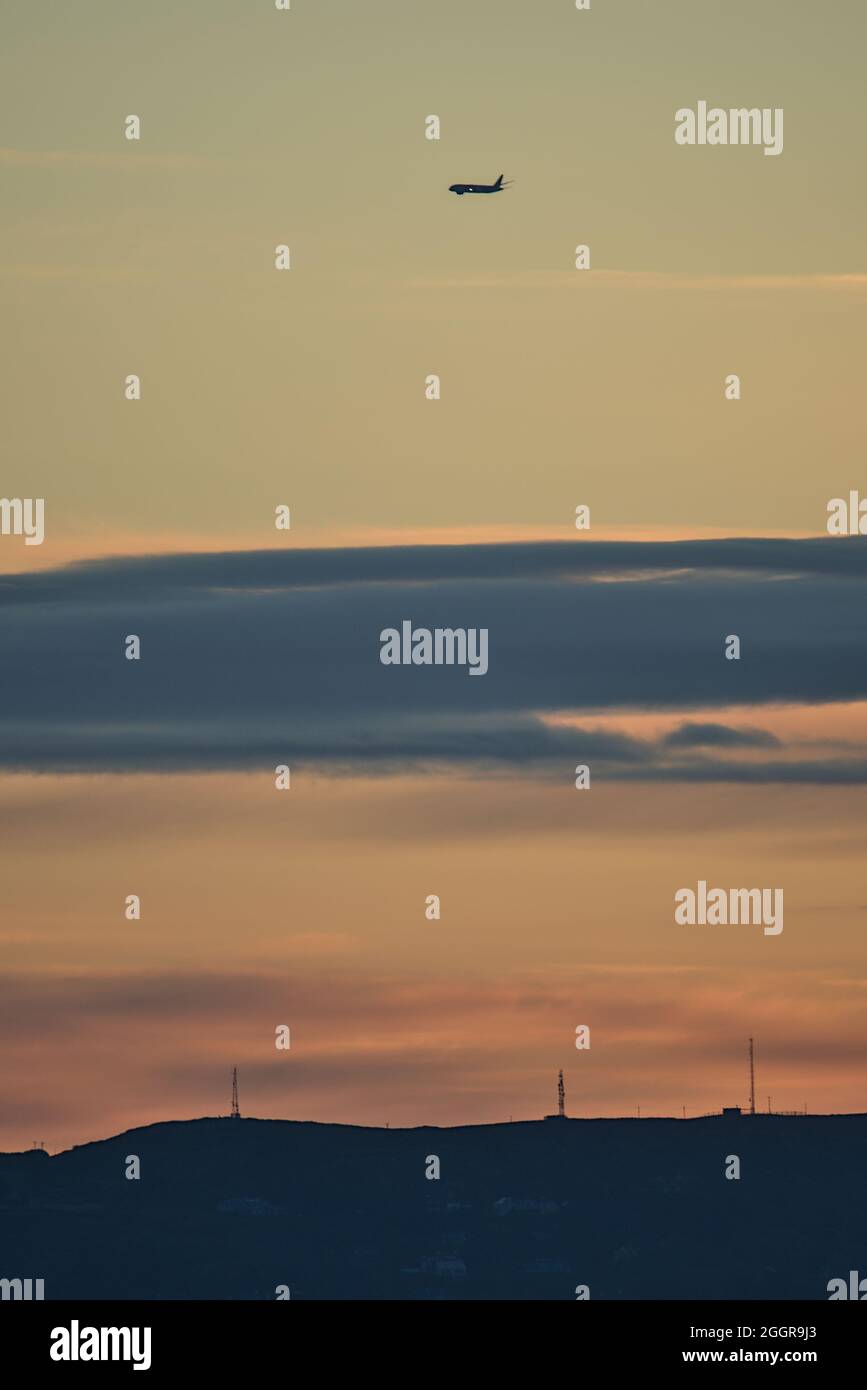 Bella vista di mattina presto dell'aeroplano che passa sopra Howth visto da Blackrock, Dublino, Irlanda prima dell'alba. Messa a fuoco morbida e selettiva Foto Stock